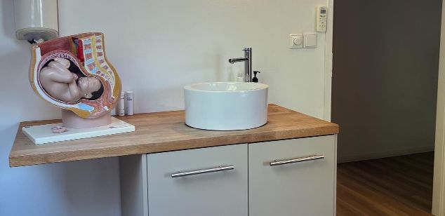 Een kamer met een beeld van een doorsneden van een zwangeren buik te zien