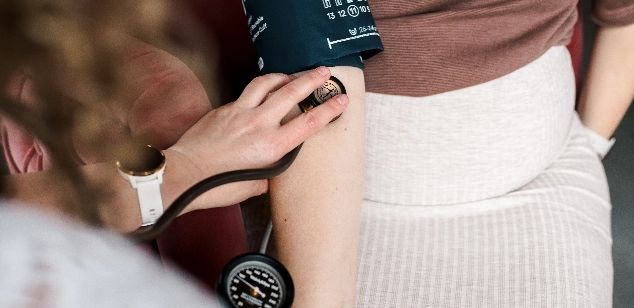 Een arm waar de bloeddruk word gemeten met een stethoscoop